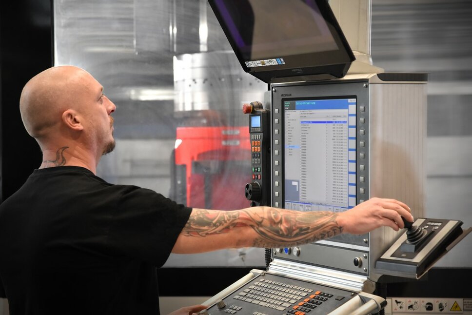 A machining technician operates a machining center in tool manufacturing.