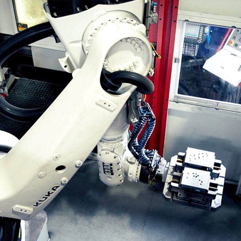 A robot arm of an automated 5-axis machining center for single-part production removes steel blocks from the pallet changer.