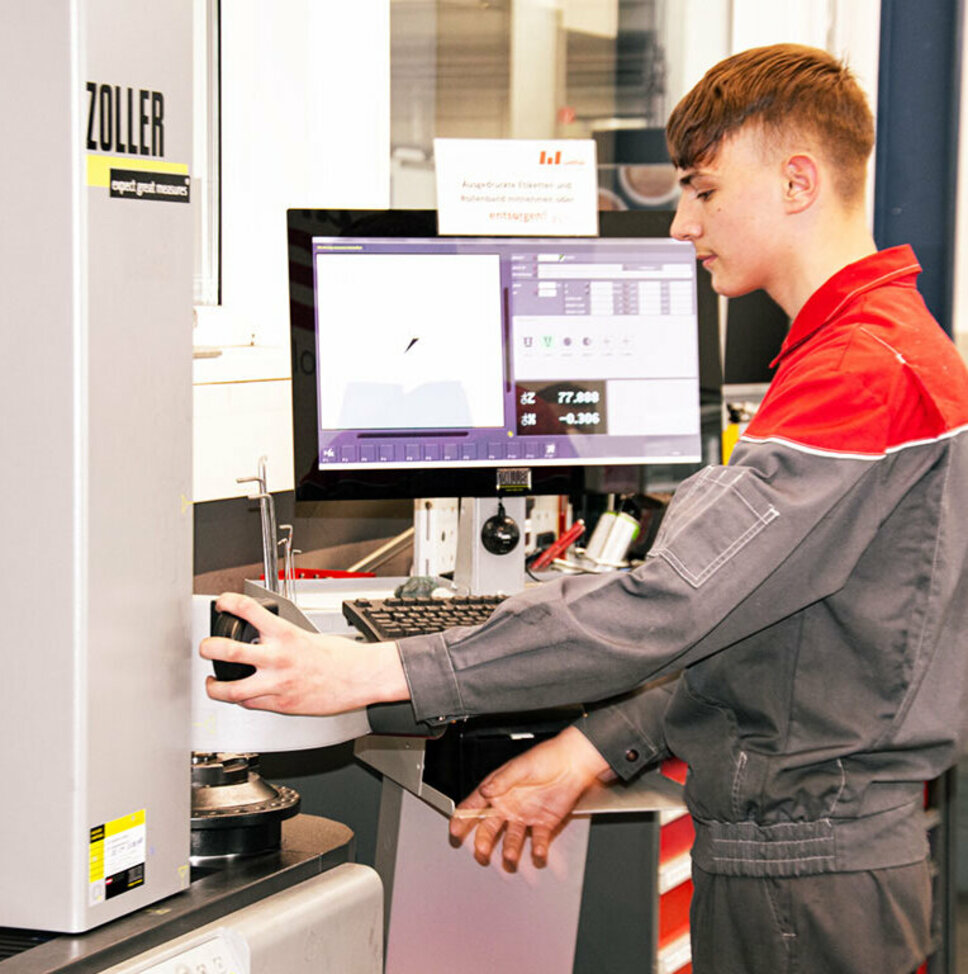 Ein Lehrling aus der Metalltechnik arbeitet konzentriert an einer technischen Anlage. Lehrstelle in Steyr bei weba Werkzeugbau in Metalltechnik bei weba kombiniert theoretisches Wissen mit praktischer Erfahrung an Anlagen.