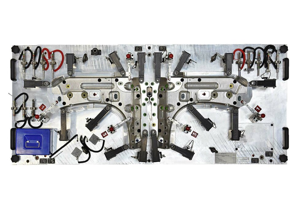  A gauge fixture from weba’s fixture construction, photographed from a bird's-eye view, is placed on a flat surface. This perspective provides a complete overview of the fixture, including all markings, scales, and specific features that are essential for the accurate inspection of manufacturing parts. The fixture is precisely engineered, with visible details that highlight its function and application in quality control. Its robust construction and clear arrangement of measurement areas demonstrate high-level engineering expertise. The bird's-eye view captures the overall structure and layout of the fixture, emphasizing its significance and efficiency in industrial metrology.