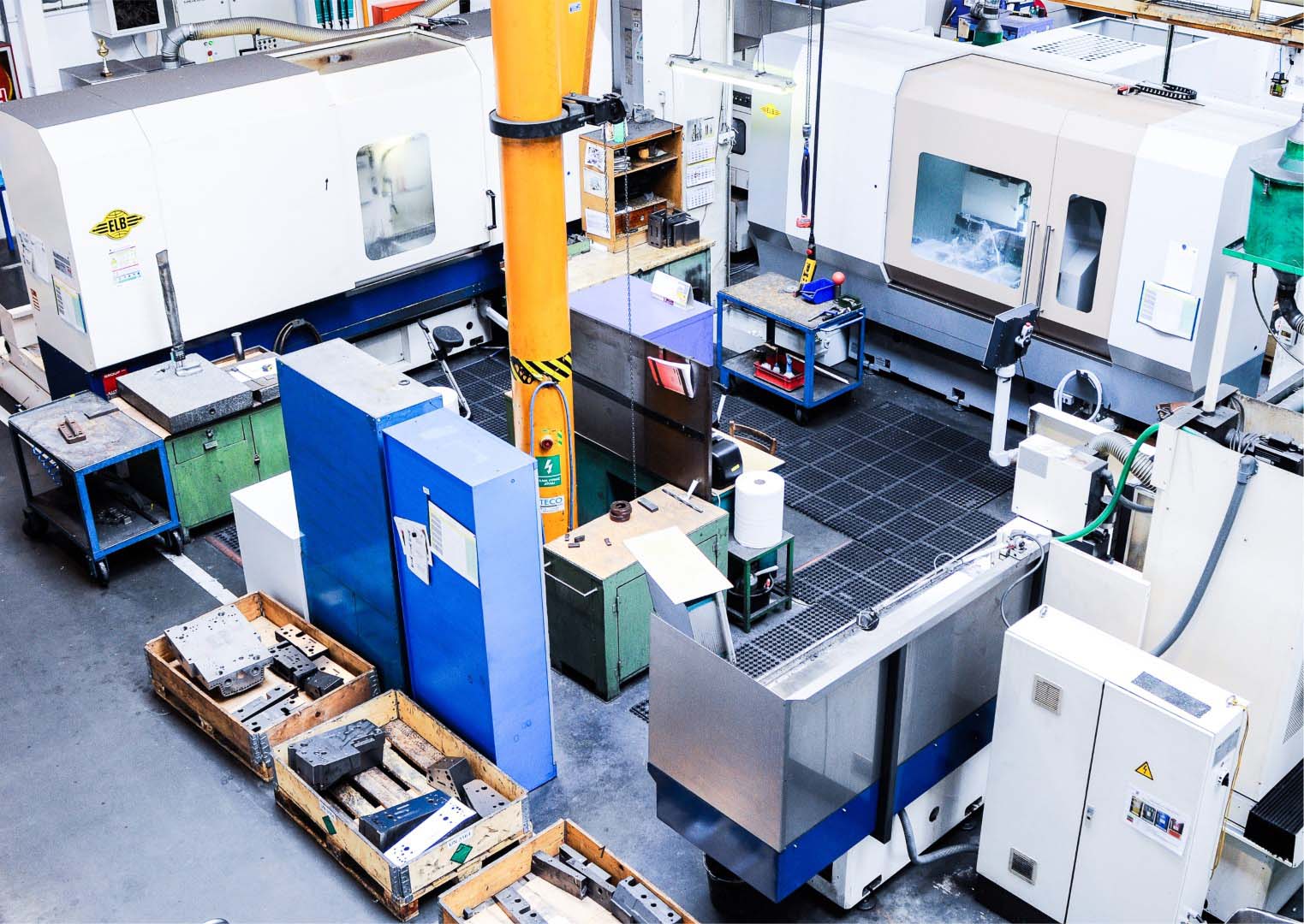 A view of a modern machine park at weba's Olomouc site, featuring multiple precision grinding machines, workstations, and tooling components in a clean and organized production environment.