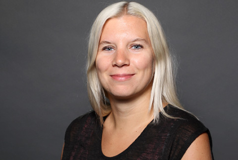 A professional portrait of Bettina Gmainer, a dedicated employee at weba Werkzeugbau, with blonde hair and a friendly smile against a neutral gray background.